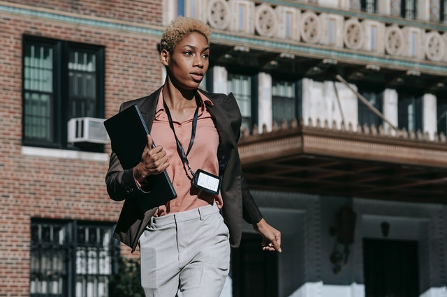 woman with lanyard and portfolio walking